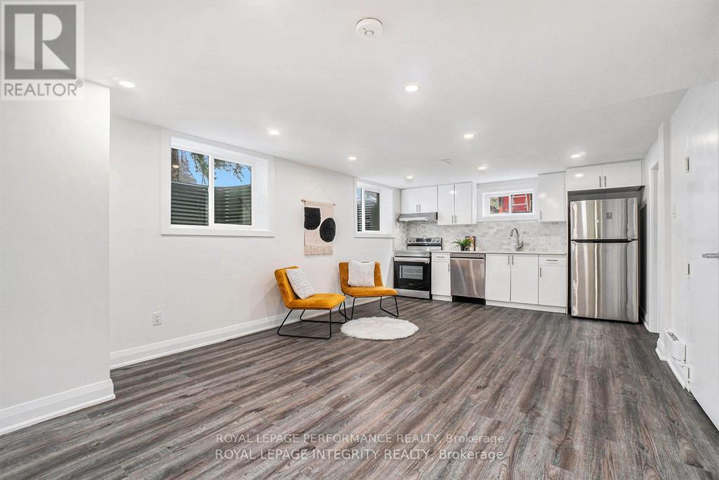 A modern kitchen with white cabinets and a wooden floor.
