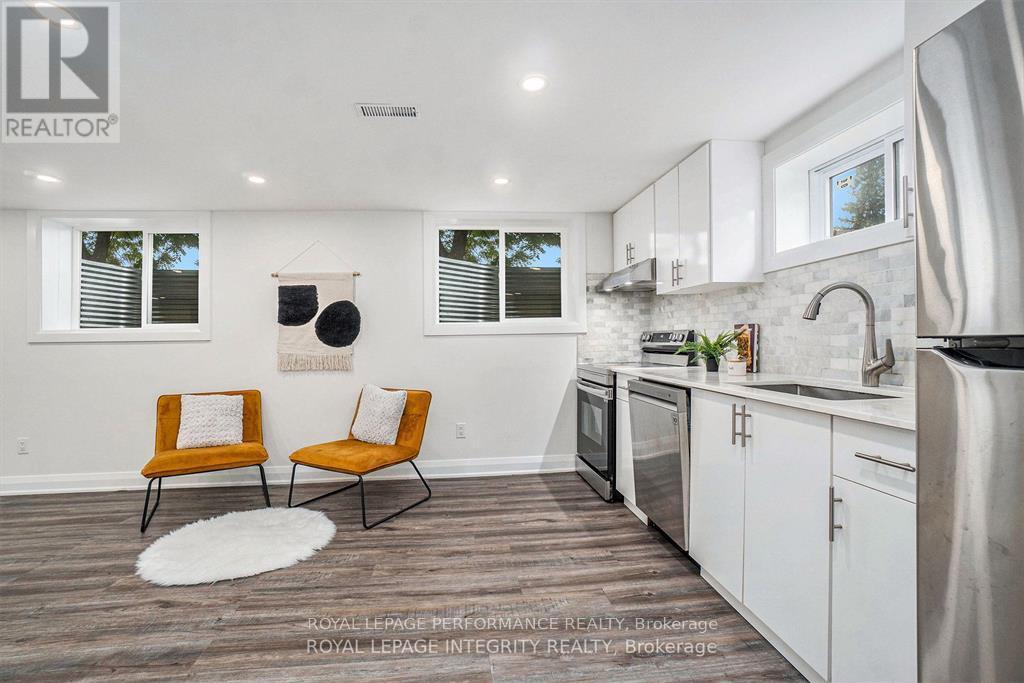 A kitchen with white cabinets and a black fridge.