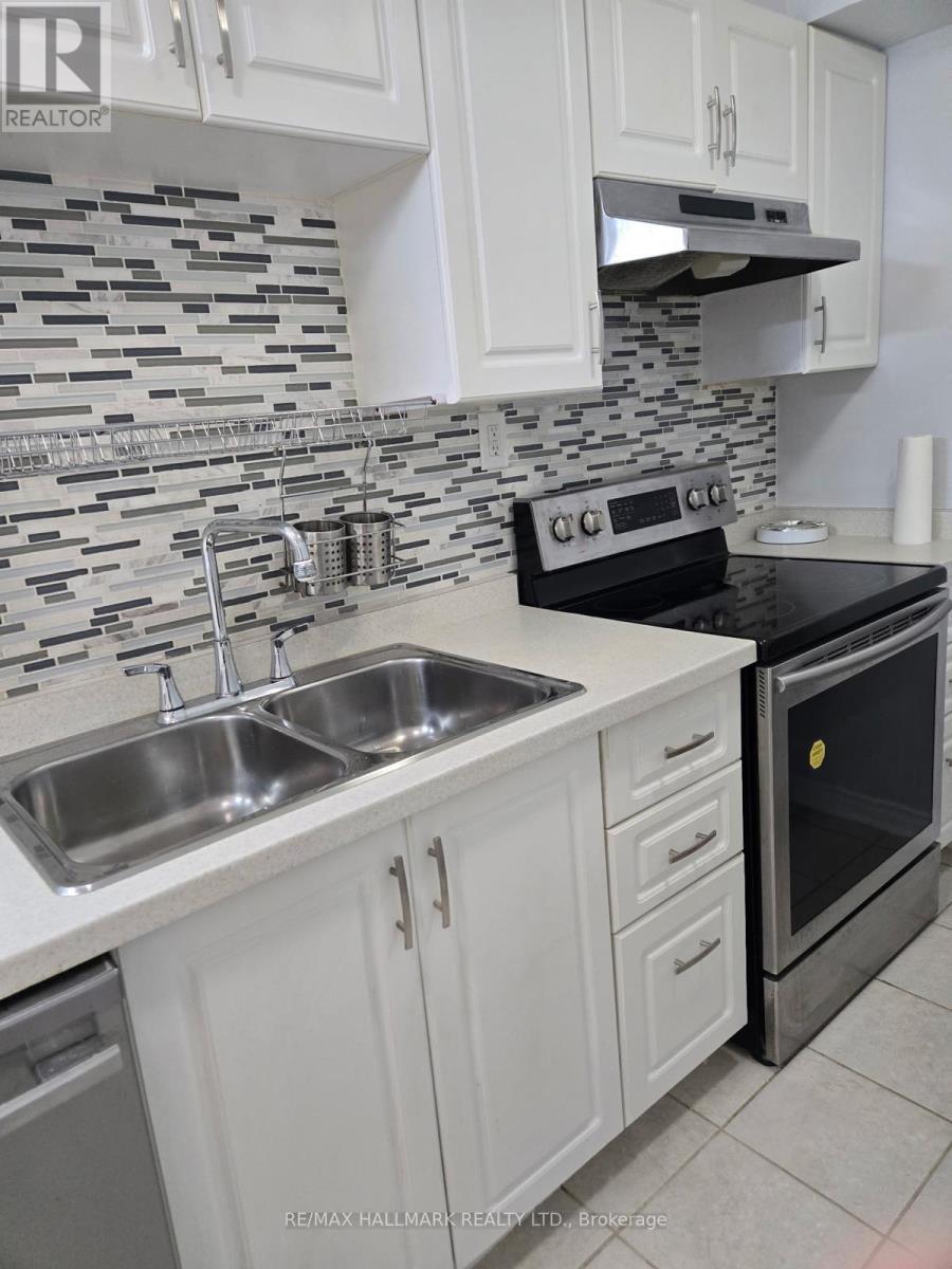 A kitchen with a black oven and a sink with two faucets.