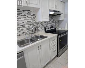 A kitchen with a black oven and a sink with two faucets.