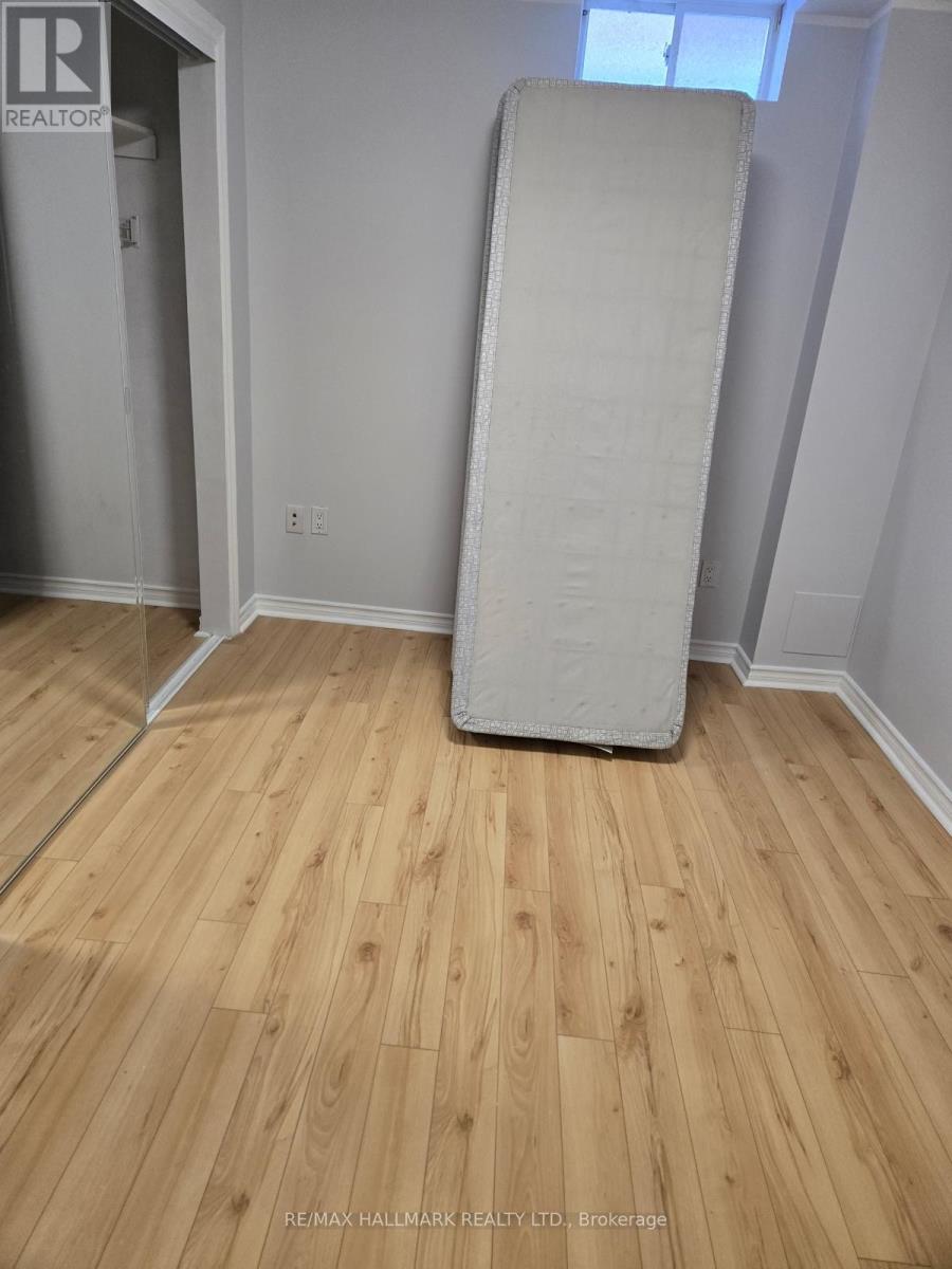 A white mattress is leaning against a wall in a room with wooden flooring.