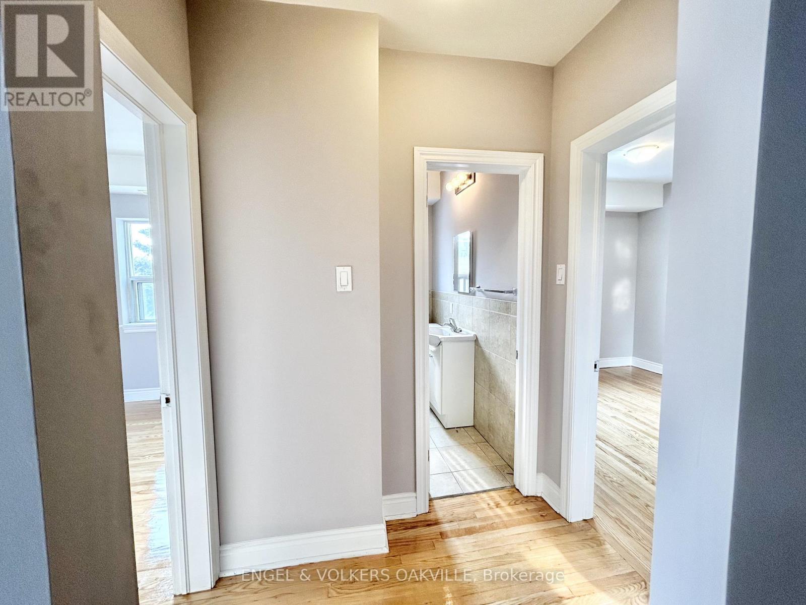A hallway with a doorway leading to a bathroom.