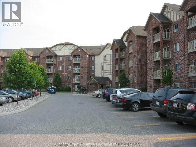 A parking lot with cars and apartment buildings in the background.