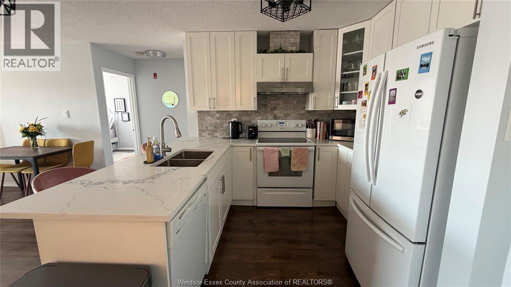 A kitchen with white appliances and a marble countertop.