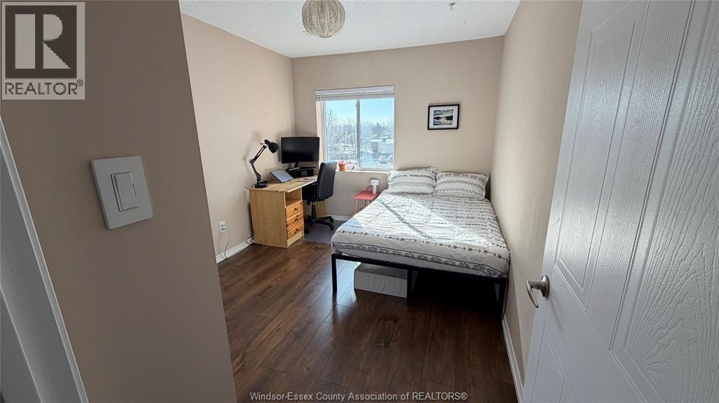 A bedroom with a bed, desk, and chair.