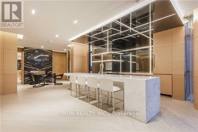 A modern office space with a bar area and a large abstract painting on the wall.