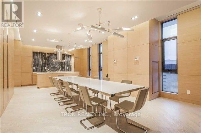A modern dining room with a long table and chairs.