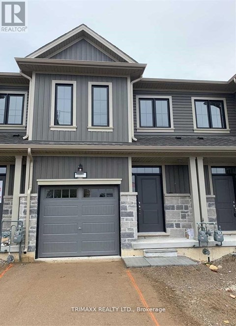 A house with a grey garage door is for sale.