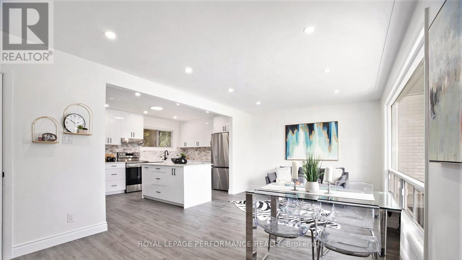 A modern kitchen with white cabinets and a dining table.