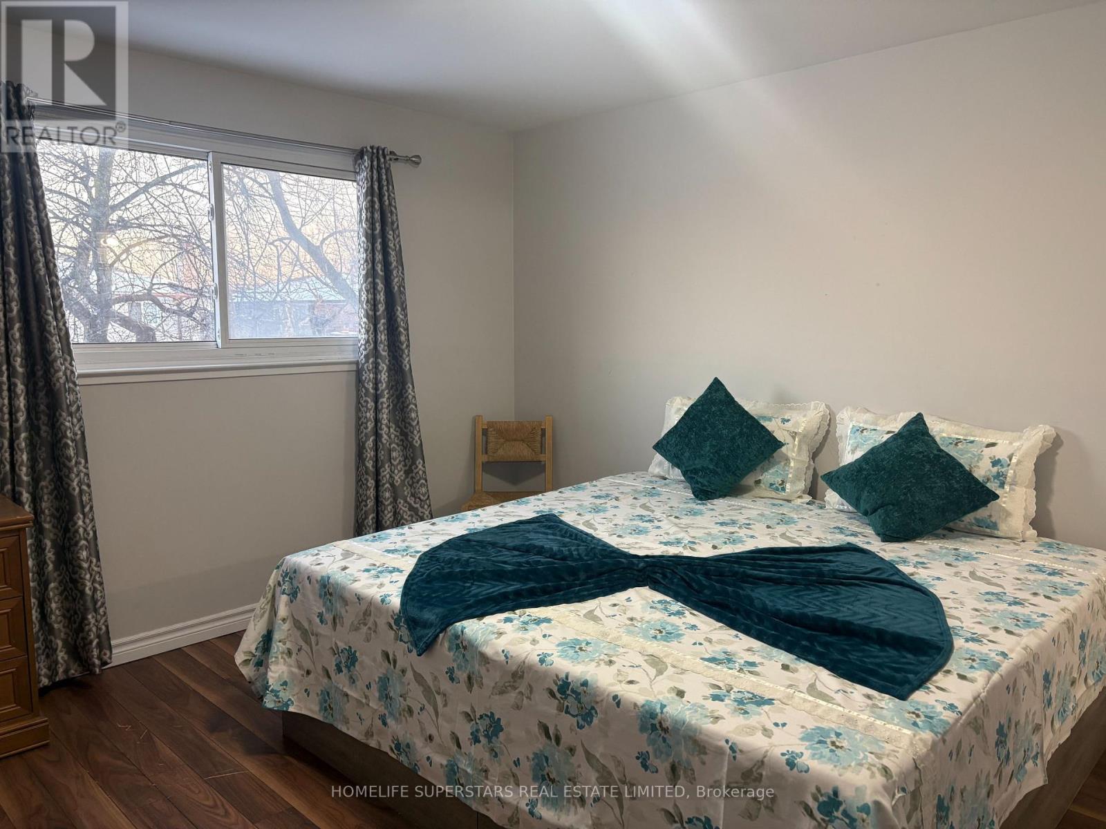 A bedroom with a bed covered in a blue and white floral comforter.