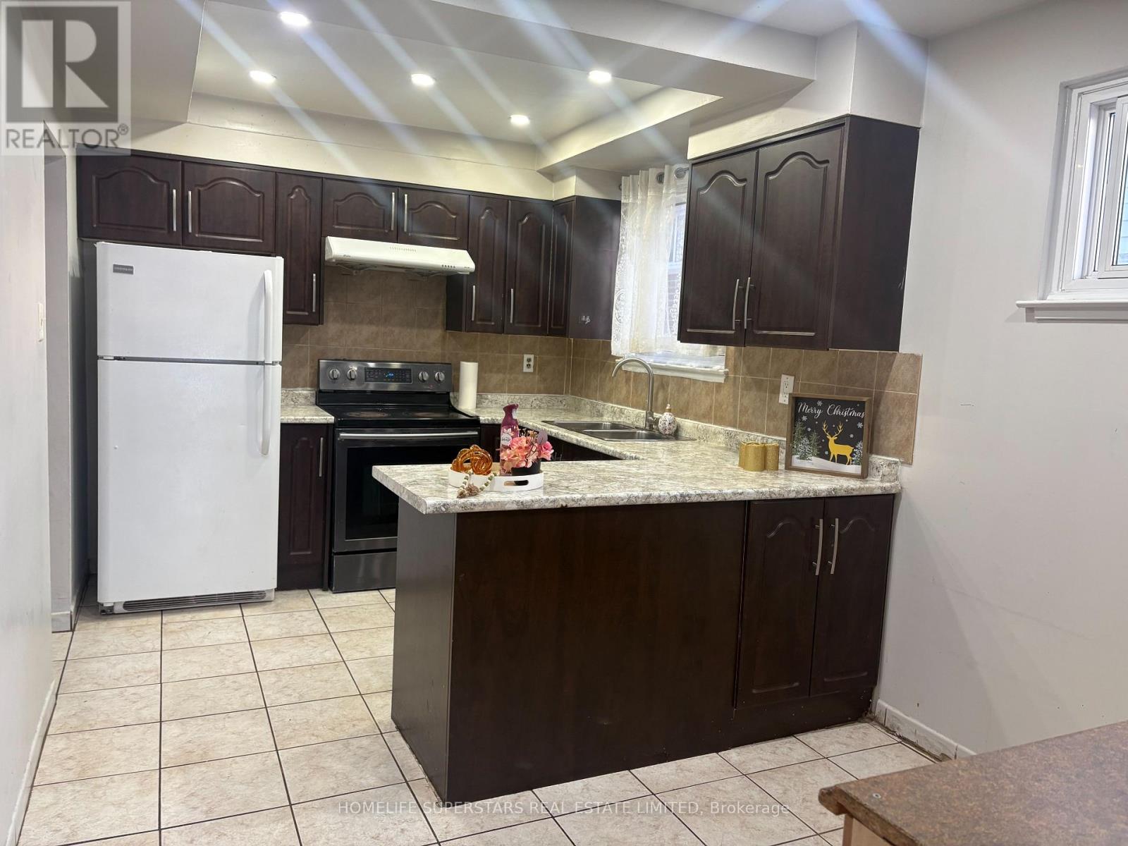 A kitchen with brown cabinets and a white refrigerator.