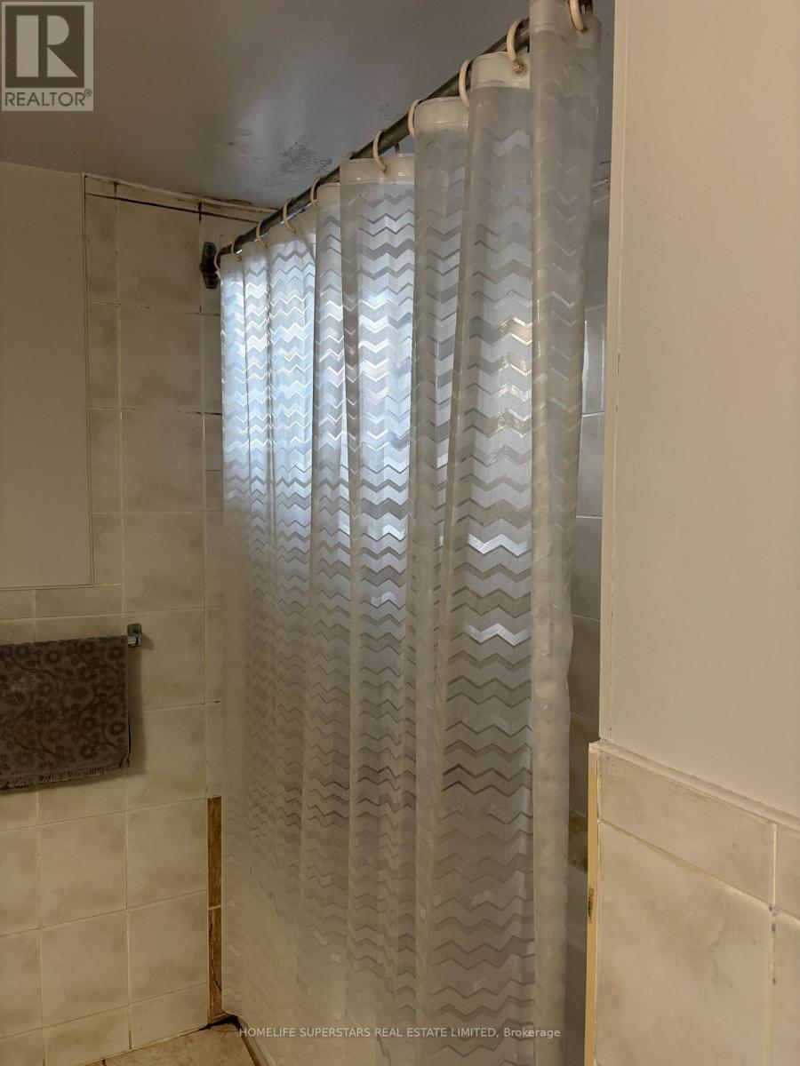 A shower curtain with a zigzag pattern hangs in a bathroom.