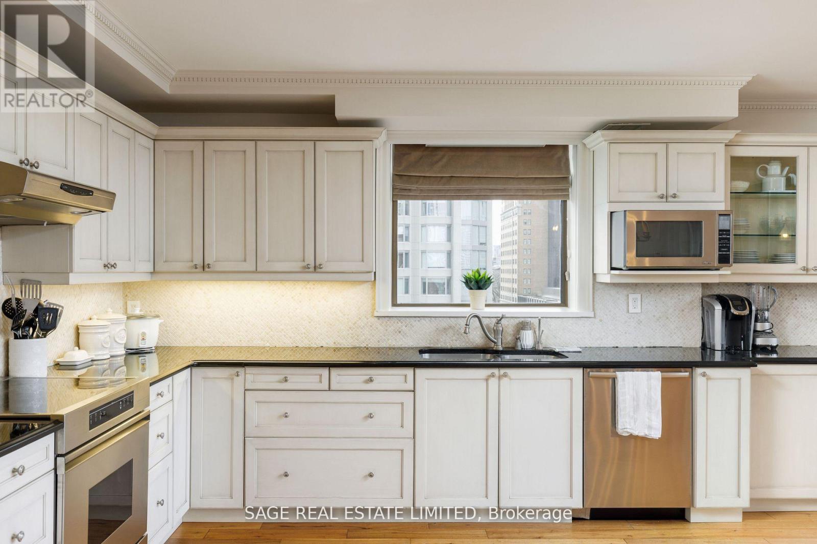 A kitchen with white cabinets and a black countertop.