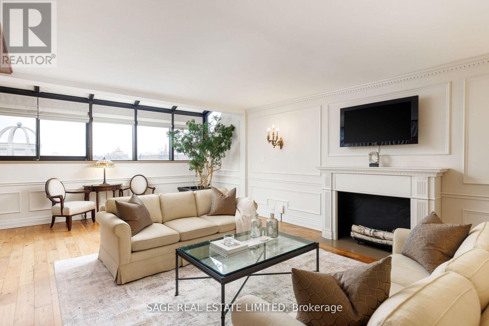 A living room with a fireplace and a television mounted above it.