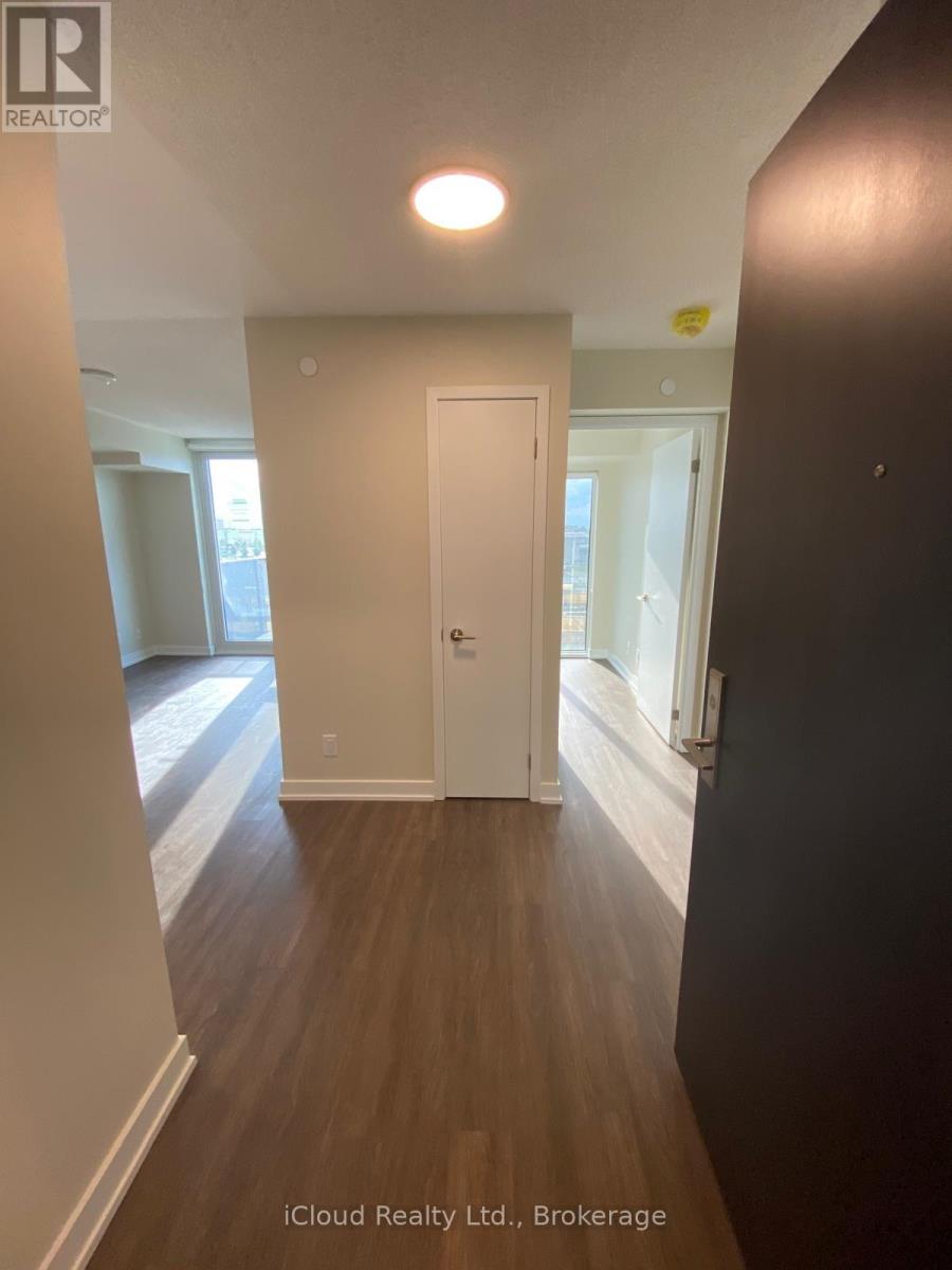 A hallway with a door and a light on the ceiling.