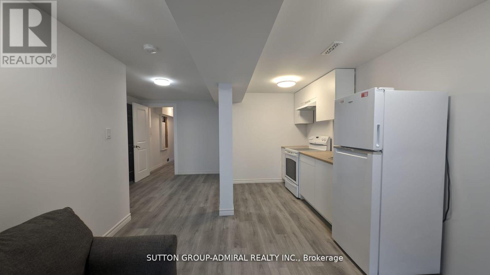 A kitchen area with a refrigerator, microwave, and oven.