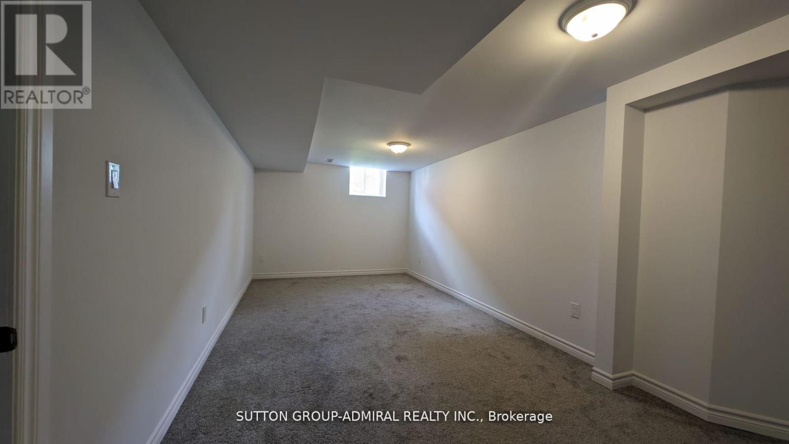 A room with a carpet floor and a door on the left side.