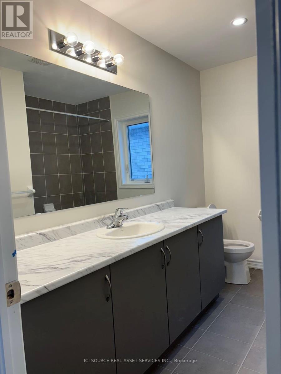 A bathroom with a sink, toilet, and a mirror.