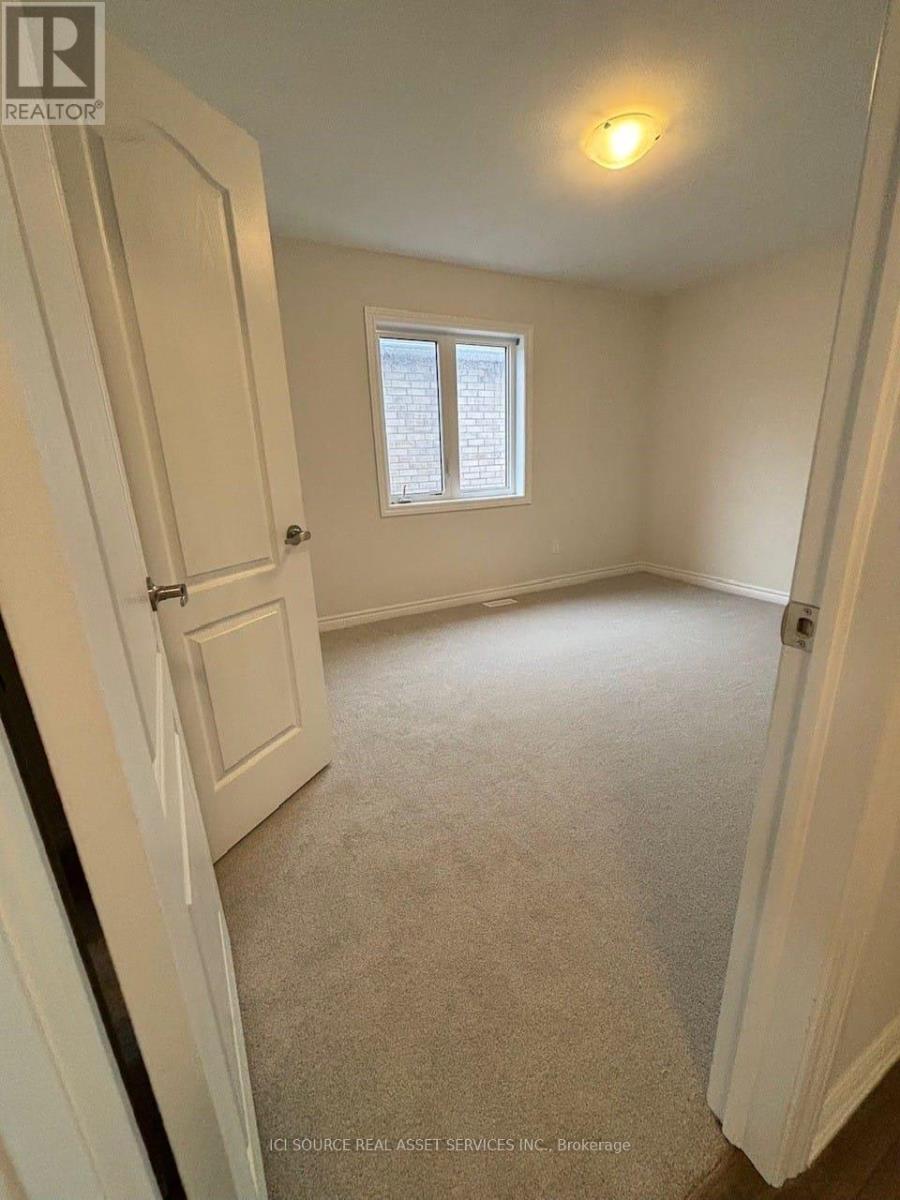 A small, empty room with a window and carpeted floor.