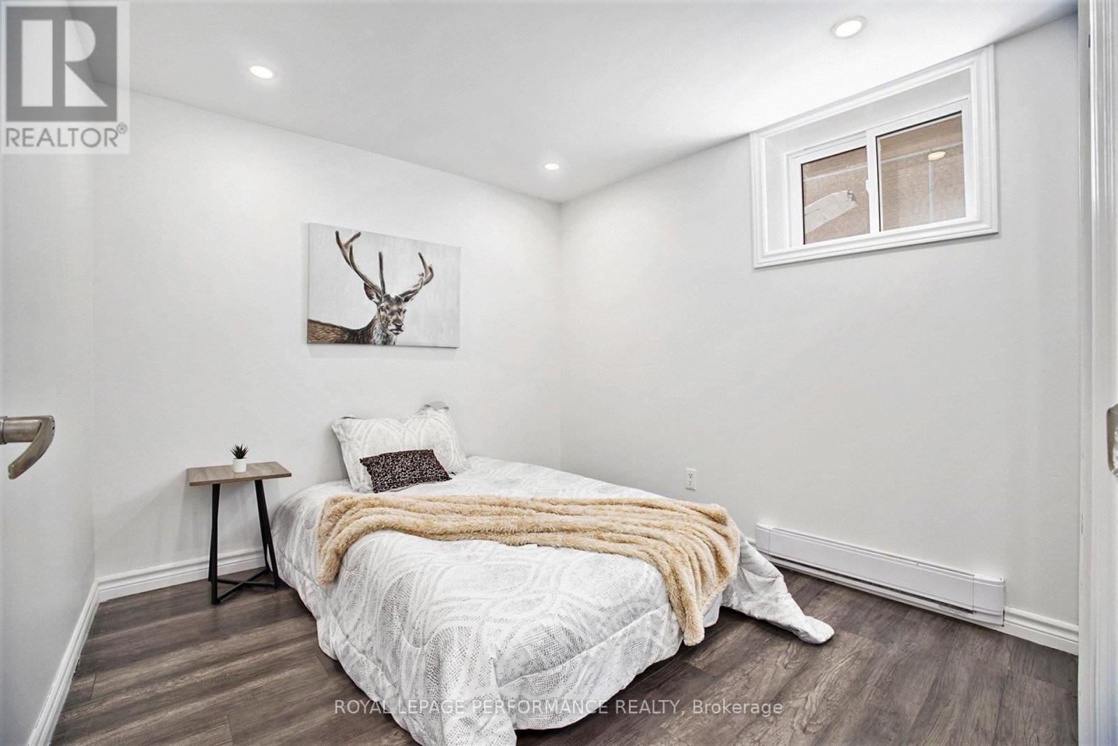 A bedroom with a bed, a deer head on the wall, and a window.