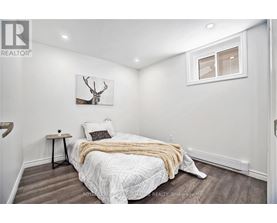 A bedroom with a bed, a deer head on the wall, and a window.