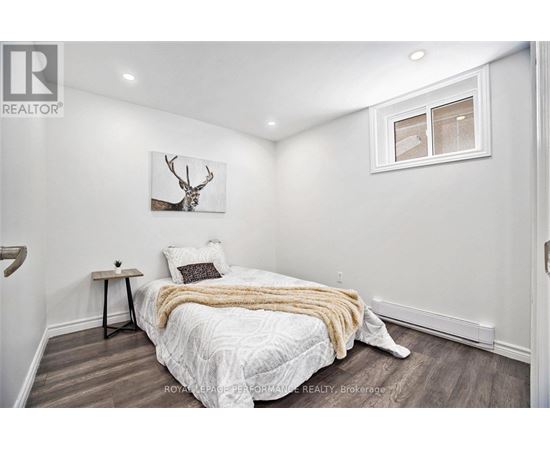 A bedroom with a bed, a deer head on the wall, and a window.
