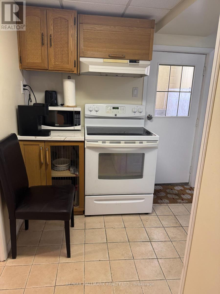 A kitchen with a white oven and a black microwave.