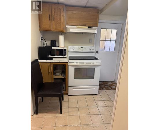 A kitchen with a white oven and a black microwave.