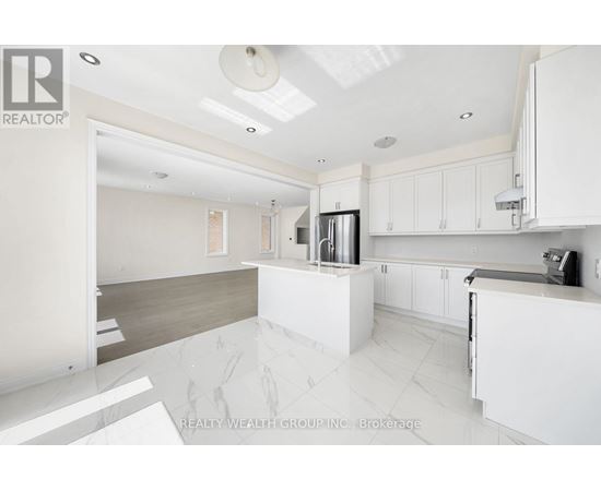 A modern kitchen with white cabinets and a marble floor.