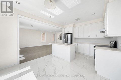 A modern kitchen with white cabinets and a marble floor.