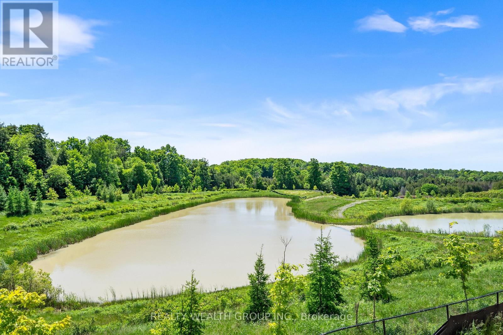A serene landscape with a lake surrounded by greenery and trees.