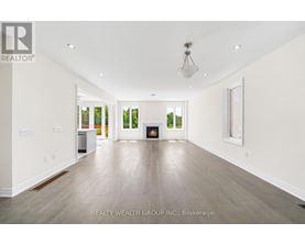 A spacious room with a fireplace and a painting on the wall.
