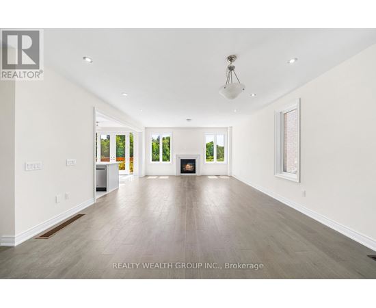 A spacious room with a fireplace and a painting on the wall.