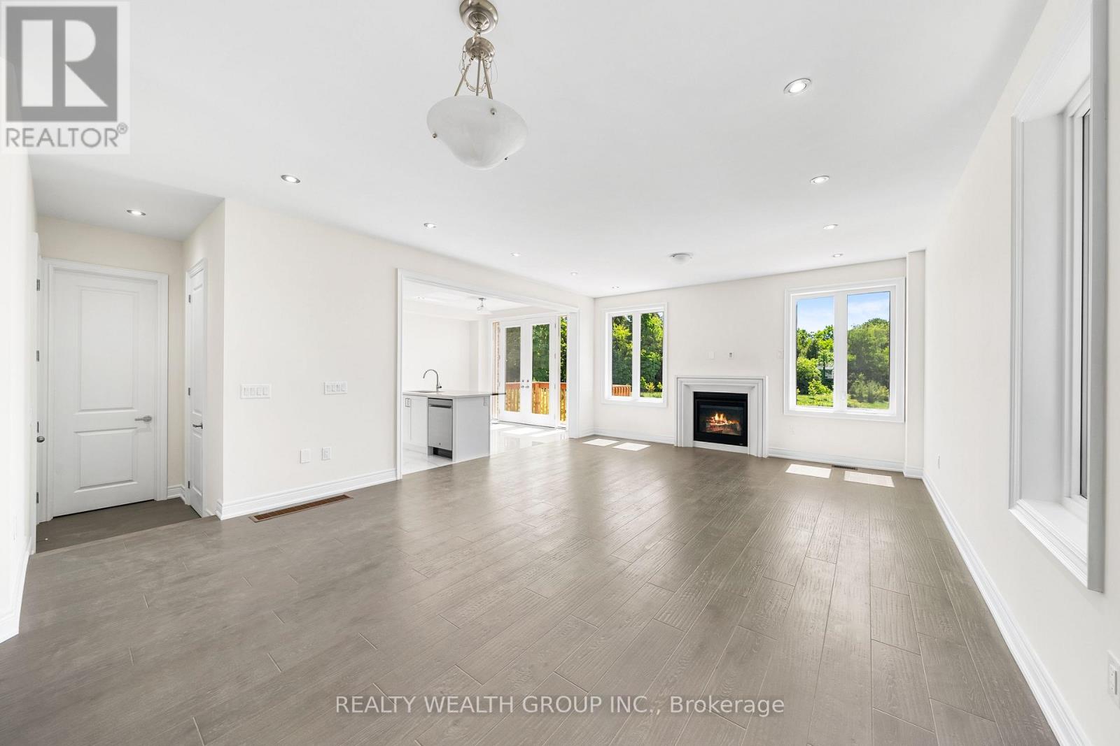 A spacious living room with a fireplace and a large window.
