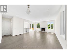A spacious living room with a fireplace and a large window.