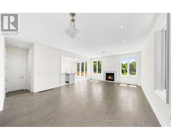 A spacious living room with a fireplace and a large window.