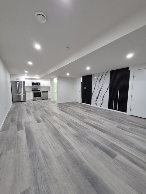 A spacious room with grey flooring and white walls.