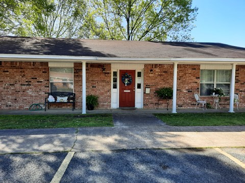 A brick house with a red door and a wreath on it.