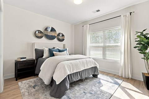 A bedroom with a large bed and a blue rug.