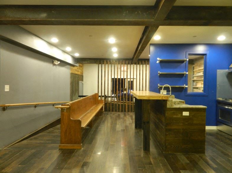 a large room with a bench and a table and a sink