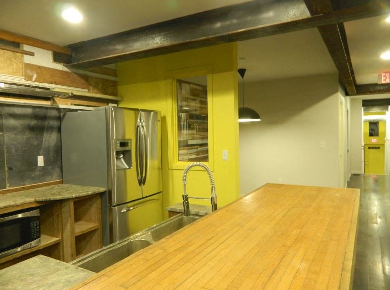 a kitchen with a wooden counter top and a stainless steel refrigerator