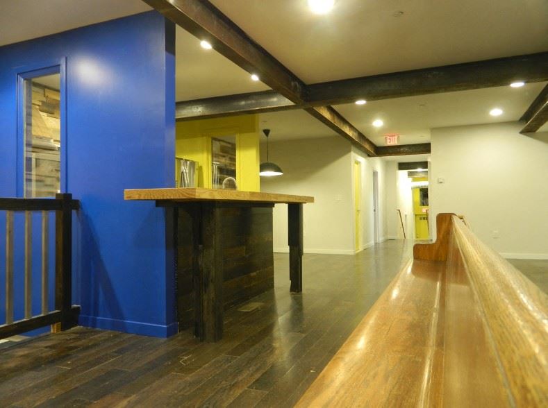 a lobby with a blue accent wall and a wooden railing