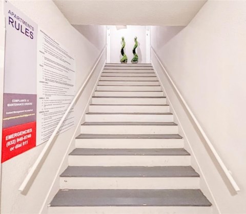 A staircase with a poster on the wall.