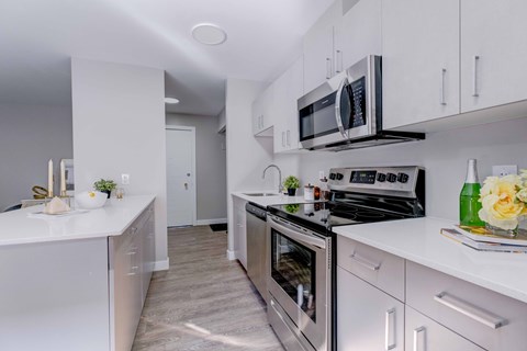 A modern kitchen with white cabinets and stainless steel appliances.