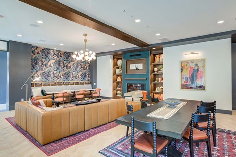 A modern living room with a large sectional sofa and a dining table set up.