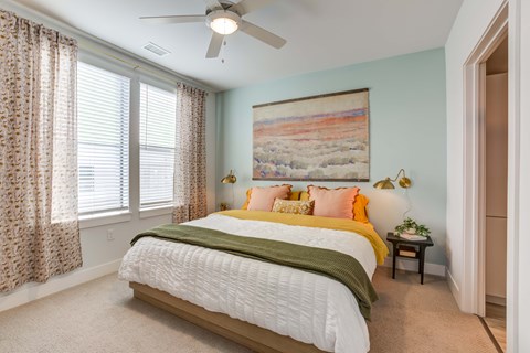 A bedroom with a large bed and a painting on the wall.