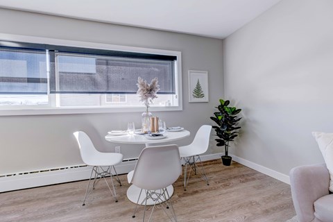 A dining room with a white table and chairs.
