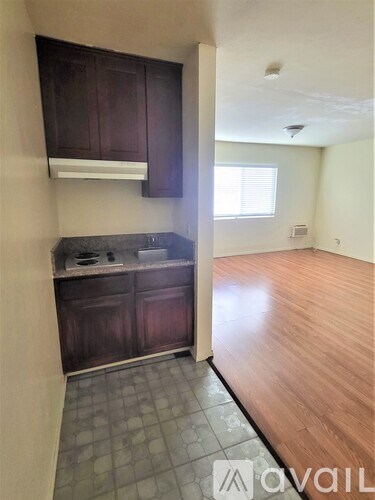 A kitchen with dark wood cabinets and a tiled floor.