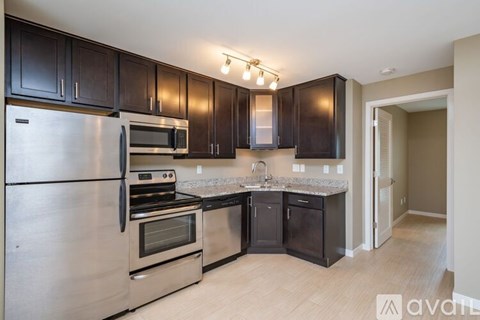 A kitchen with dark brown cabinets and stainless steel appliances.