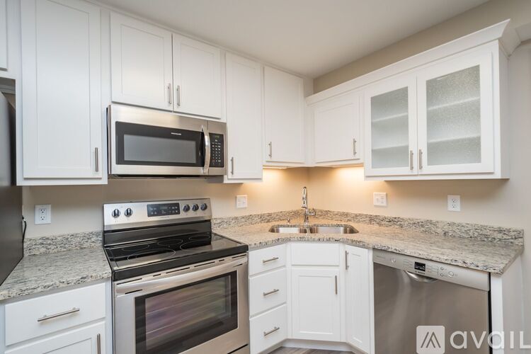 A kitchen with white cabinets and granite countertops.